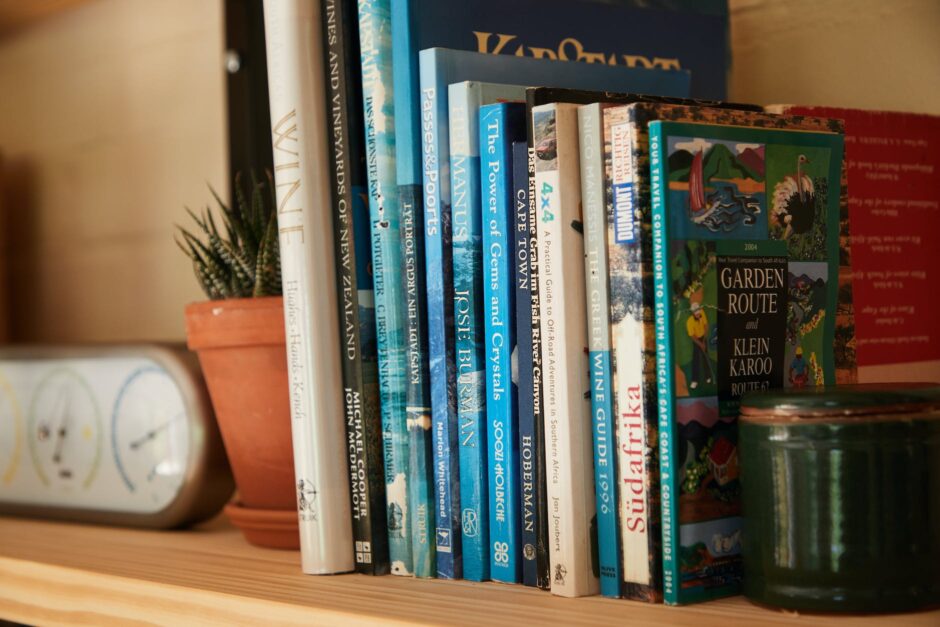 books placed on shelf with potted plants